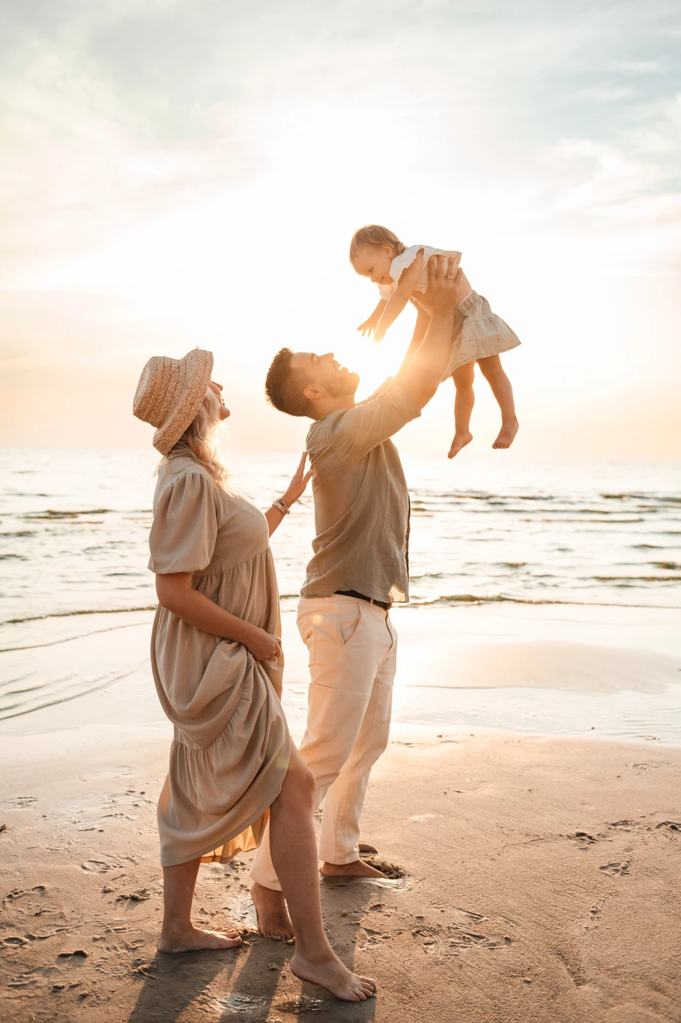 Родинна фотосесія на пляжі під час заходу сонця над Дніпром.А